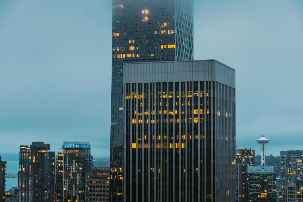 Seattle cityscape featuring skyscrapers and iconic Space Needle under cloudy sky.